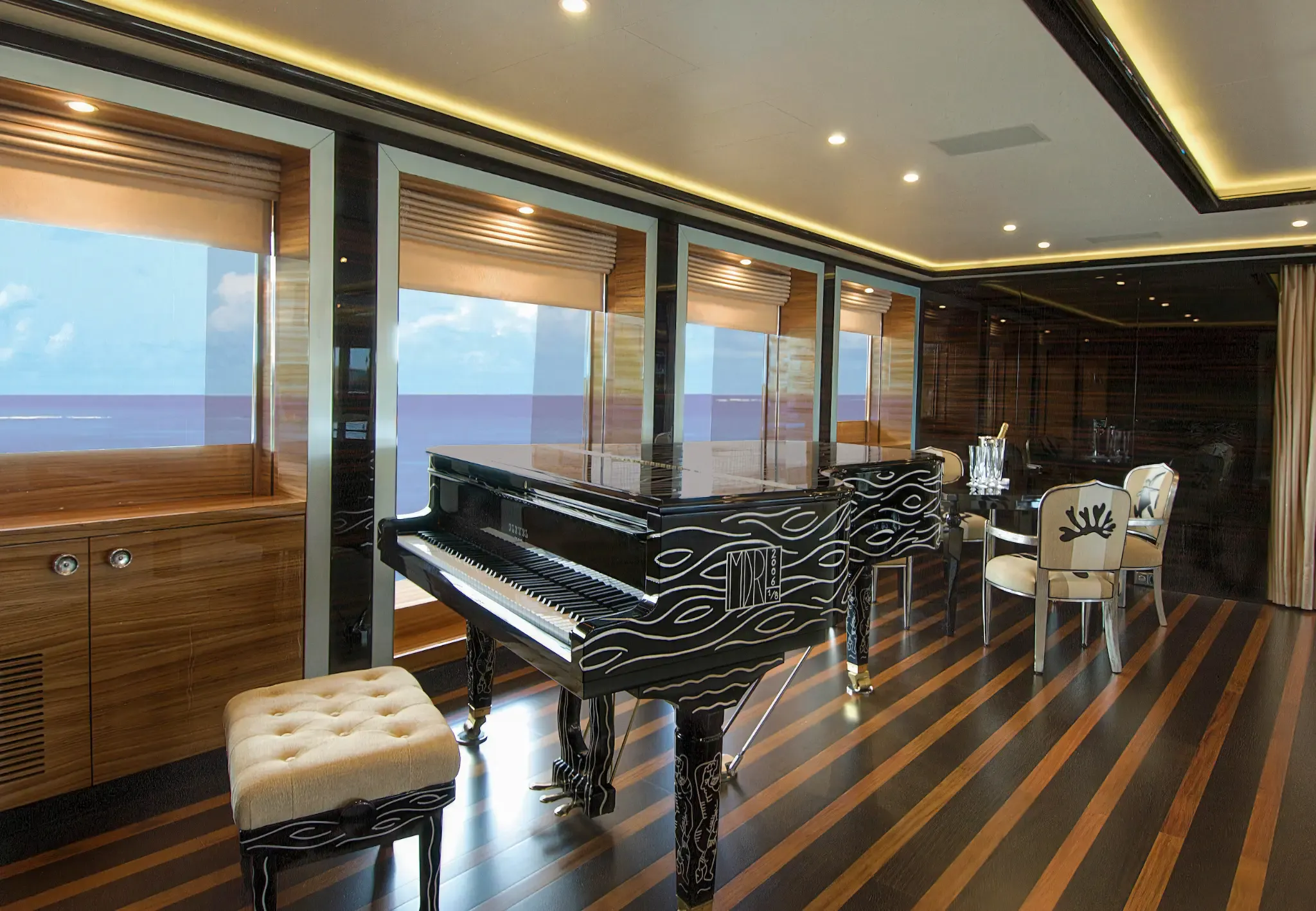 Black-lacquered Pleyel grand piano with white wave-motif etching in ALFA NERO's main salon